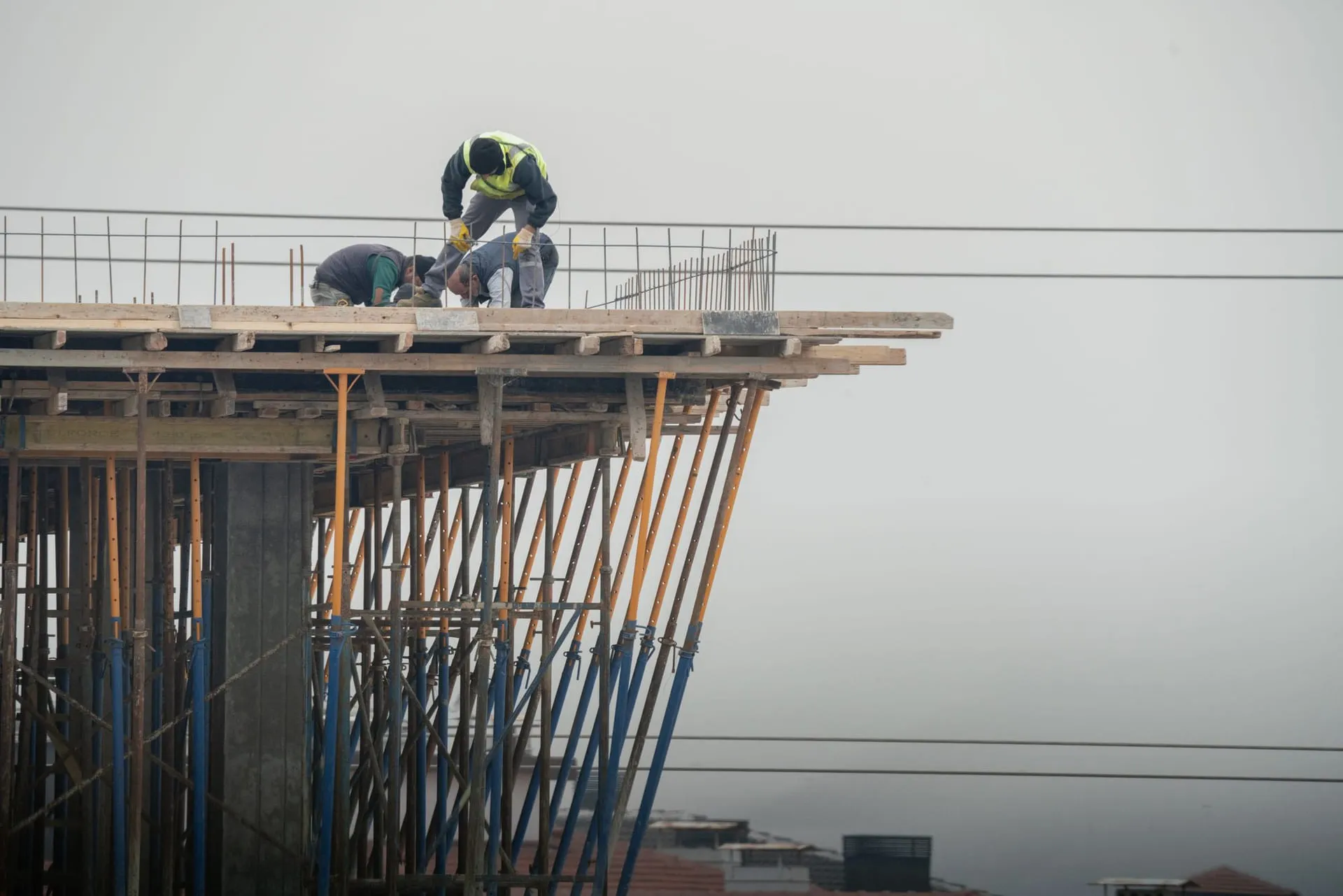 Construction crew working together on a high-rise building deck
