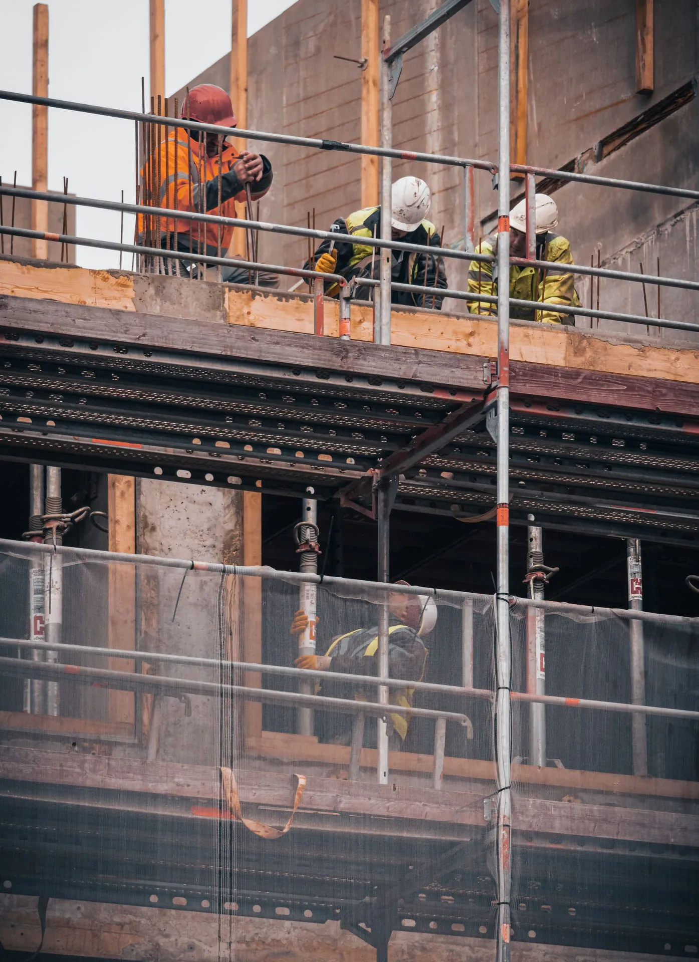 Construction workers on scaffolding along a building facade