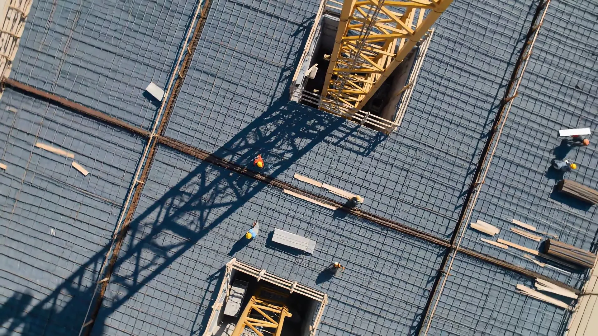 Aerial view of a reinforced concrete deck and tower crane on a building going up